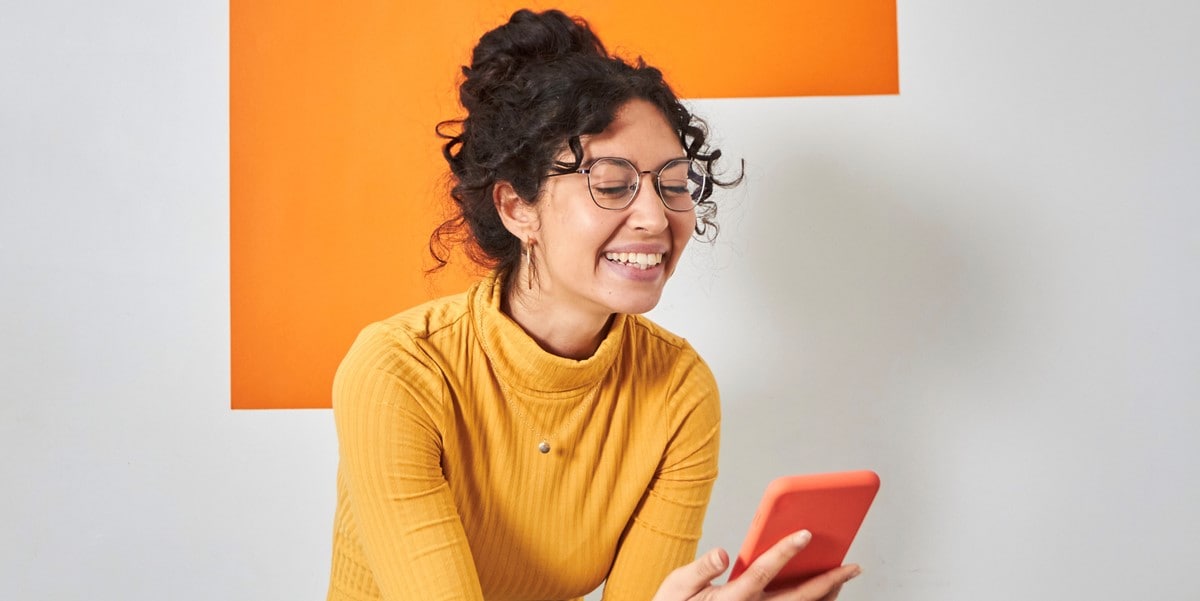 woman looking at cellphone in hand